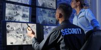 Security guards monitoring modern CCTV cameras indoors